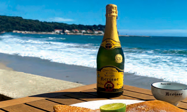 Bouteille de cidre Kerisac et crêpe sucrée sur table en terrasse face à la plage des Sablettes, La Seyne-sur-Mer